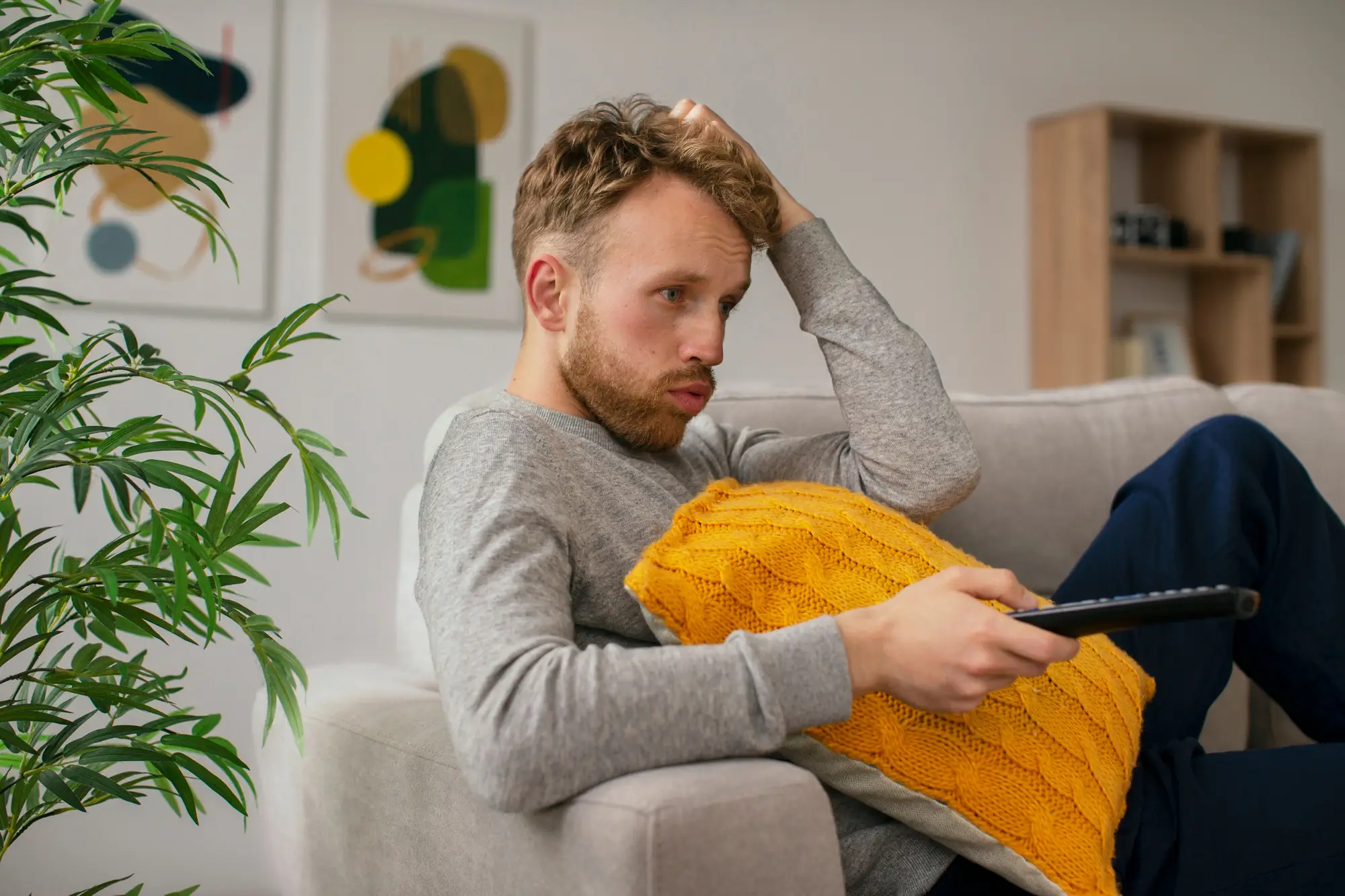 ADHD u dorosłych – zmęczony, rozkojarzony mężczyzna na kanapie, objawy trudności z koncentracją